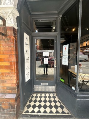 Glass door with grey frame. Push silver handle from right to open.