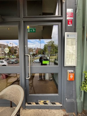 Glass door with grey frames. Push from left to open.
