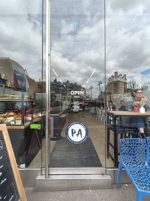 Glass door with silver handle on left, push to open.