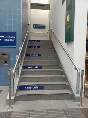 From street facing venue. Staircase ahead, leading up. Handrails along left and right.