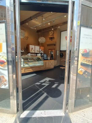Glass doors with silver metal frame. Push from middle to open.