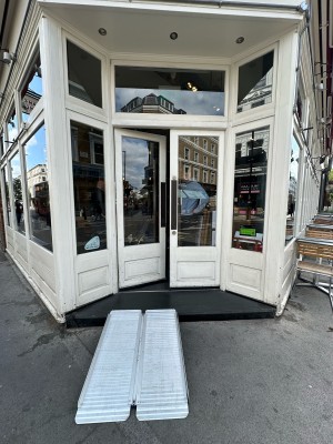 White and glass panelled doors. Push from centre to open. Doormat after doors.