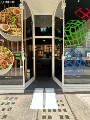Glass door with white frame. Push silver handle from left to open.