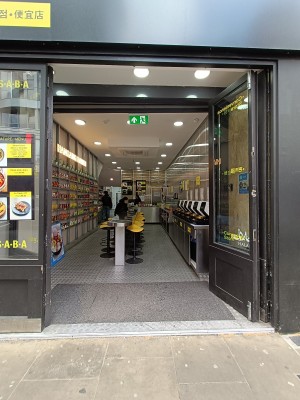 Glass door with black, wooden doors ahead. Push to open.