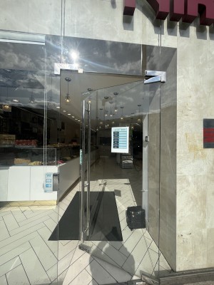 Push silver handle on left of glass door to open.
