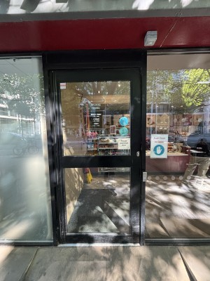 Glass door with black frames. Push from right to open.