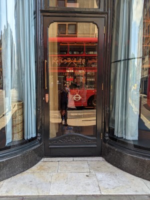 Glass door with black frame and metal handle. Pull from left to open.