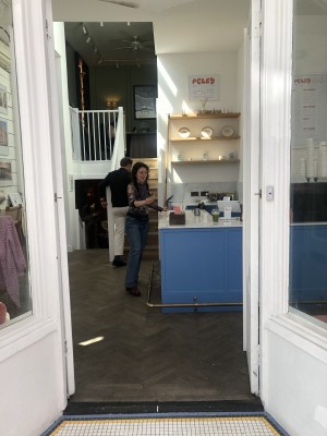 Glass doors with white frame. Push handle in centre to open.