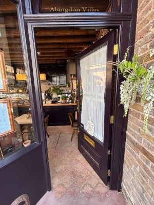 Glass door with brown frames. Push from left to open.