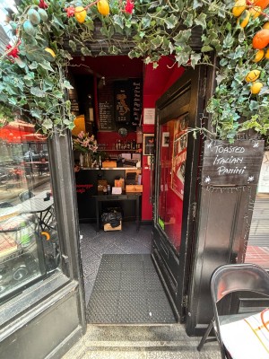 Glass door with black frames. Push from left to open.