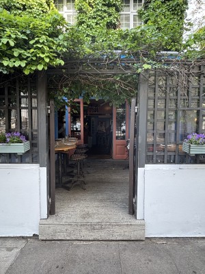 From sidewalk facing venue. Wooden doors ahead. Push from center to open.