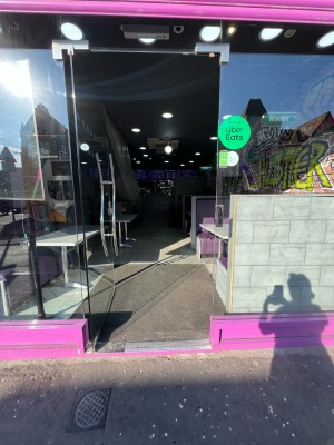 From sidewalk facing venue. Glass panelled door ahead. Push from metal handle on right to open.