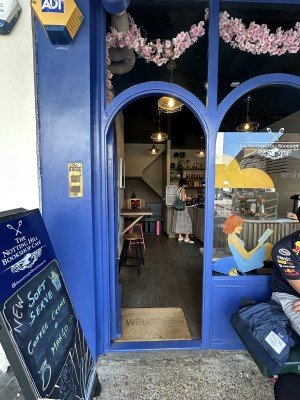 Glass door with blue frame. Push gold handle from right to open.