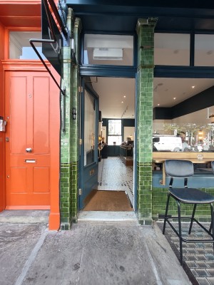 Blue framed glass door. Push golden handle on right to open.