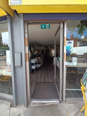 Glass door with silver, metal frame. Push silver handle on left to open.