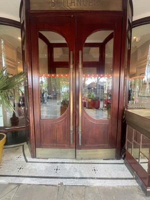Brown glass and wooden door ahead. Pull golden handles from centre to open.
