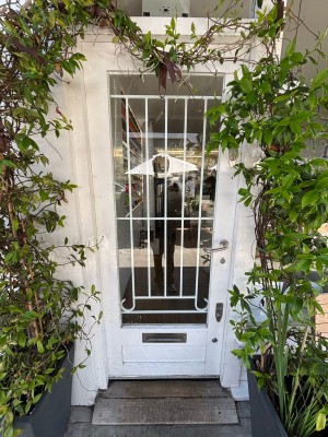 Glass door with white frames ahead. Push from right handle to open.