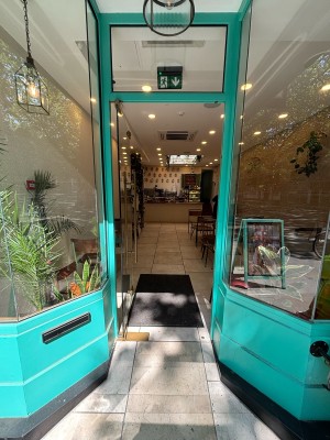 Glass door with green frames. Push from right handle to open.