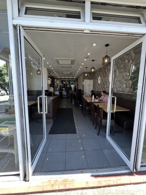 Glass double doors. Push silver handle to open.