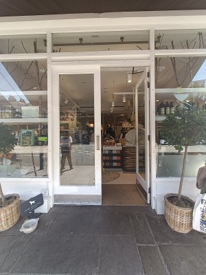 Glass door with white wooden frame. Push from middle to open.