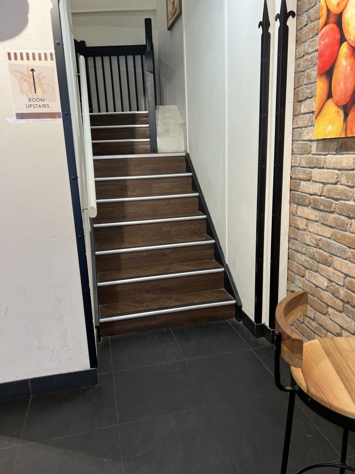 Rails on both sides of stairway with three small  landings. Edges of every step are contrasting steps.