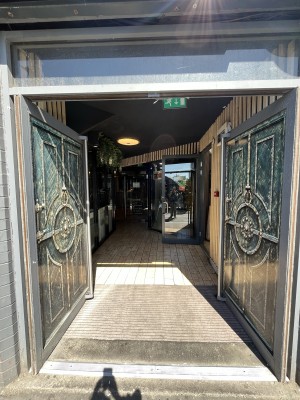 Preceding double doors. Push silver handle to open.