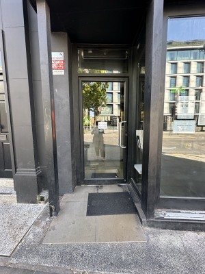 Glass door with black frame. Pull silver handle from right to open.