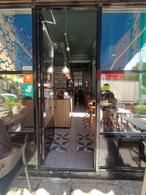Glass door with black, wooden frame. Push handle from right to open.