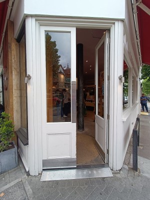 Glass door with white wooden door ahead. Push from middle to open.