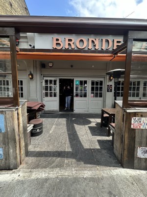 From pavement facing venue. Open archway ahead.