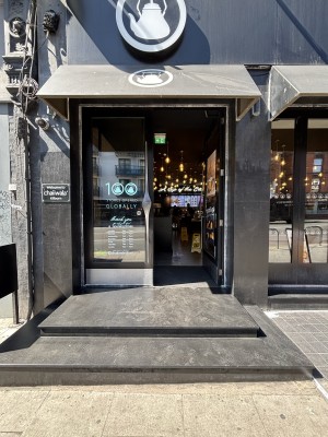 Glass doors with black frame. Push via handles in center to open.