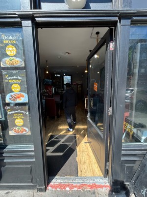 Glass door with black frames. Push from left handle to open.