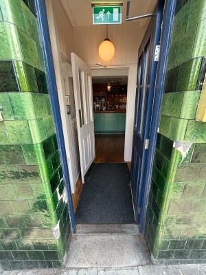 Blue door with glass panels ahead. Push from left to open.