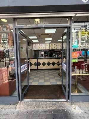 Glass doors with grey frame ahead. Push via handles in center to open.