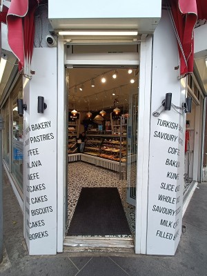Glass door with silver handle on left. Push to open.