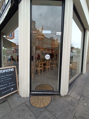 Glass door with black, black wooden frame. Push silver handle on left to open.