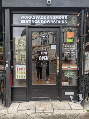Glass door with black frame. Push from metal handle on right to open.
