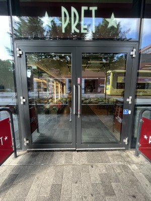 Glass doors ahead. White doorbell to right. Push silver handle in centre to open.