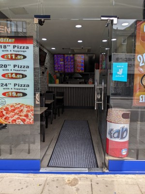 Glass door with metal handle on left. Push to open.