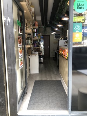 Glass door with black frame. Push from right to open.