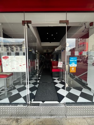 One step to glass door ahead. Push from silver handle on right to open.