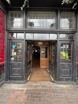 Glass doors with black frame ahead. Push from center to open.