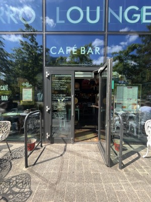 Glass doors with silver handles in centre.  Black handrails on left and right. Pull handle in centre to open doors.