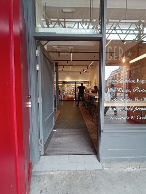 Glass door with grey, wooden door. Silver handle on right, push to open.