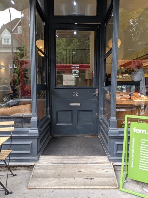 Dark grey door with glass panel. Push from metal handle on right to open.