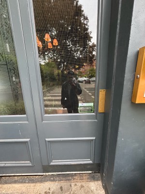 Glass door with grey frames. Push from right to open.