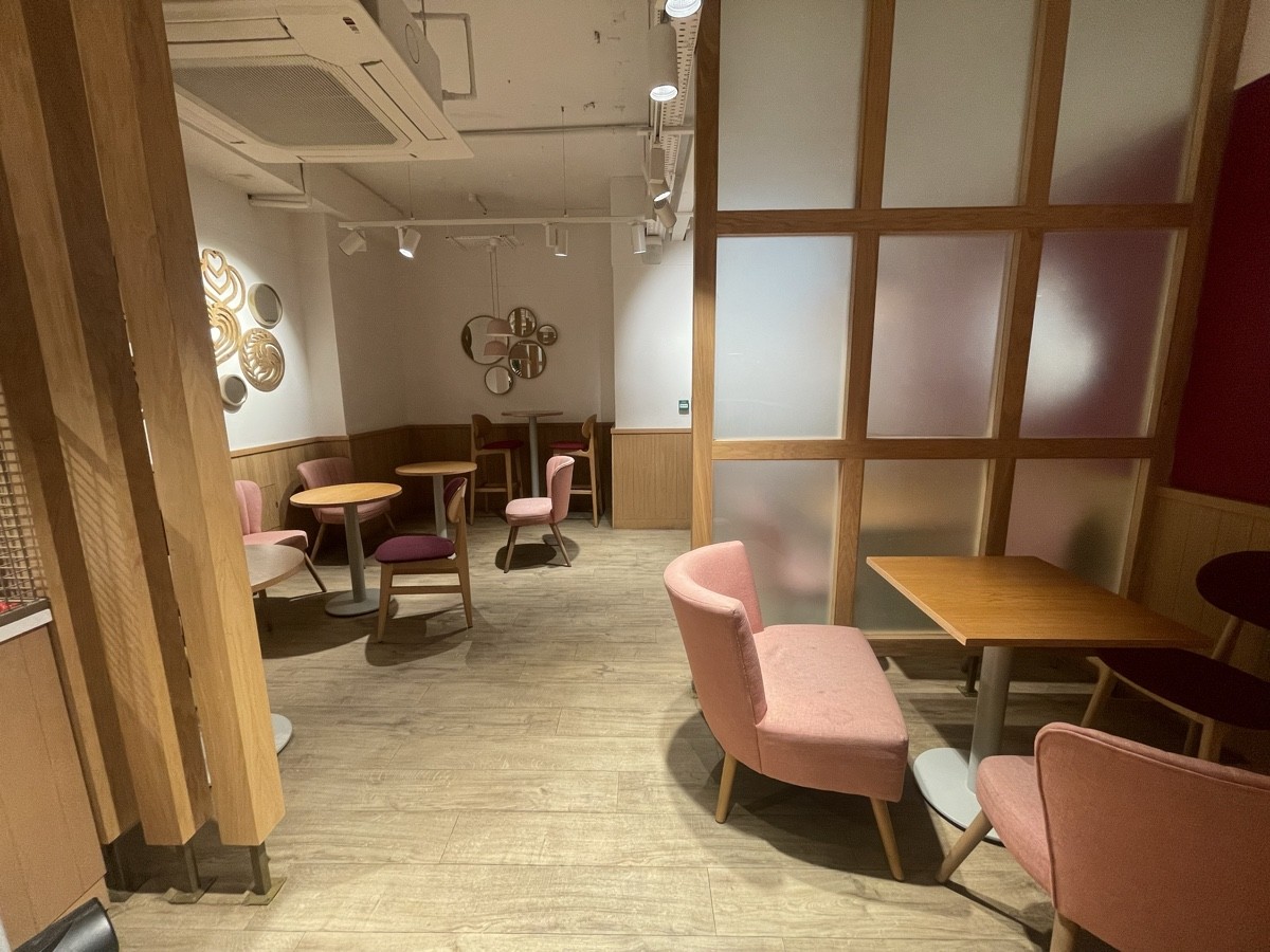From opening facing left. Armchairs and table on right. Glass divider beyond it.