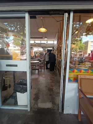 Glass door with blue metal frame. Push from left to open.