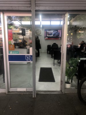 Glass doors with grey frame. Push handle in centre to open. Pole in centre before doors.