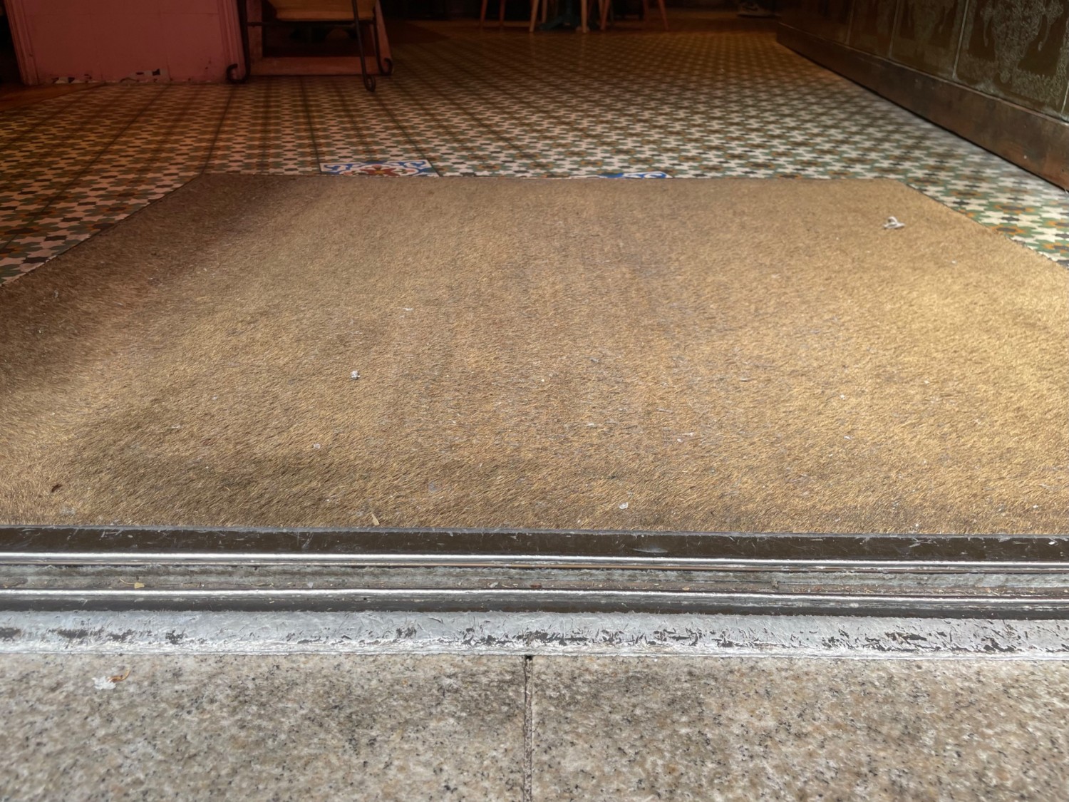 Metal bump at centre of doorway. Carpeted area following bump.